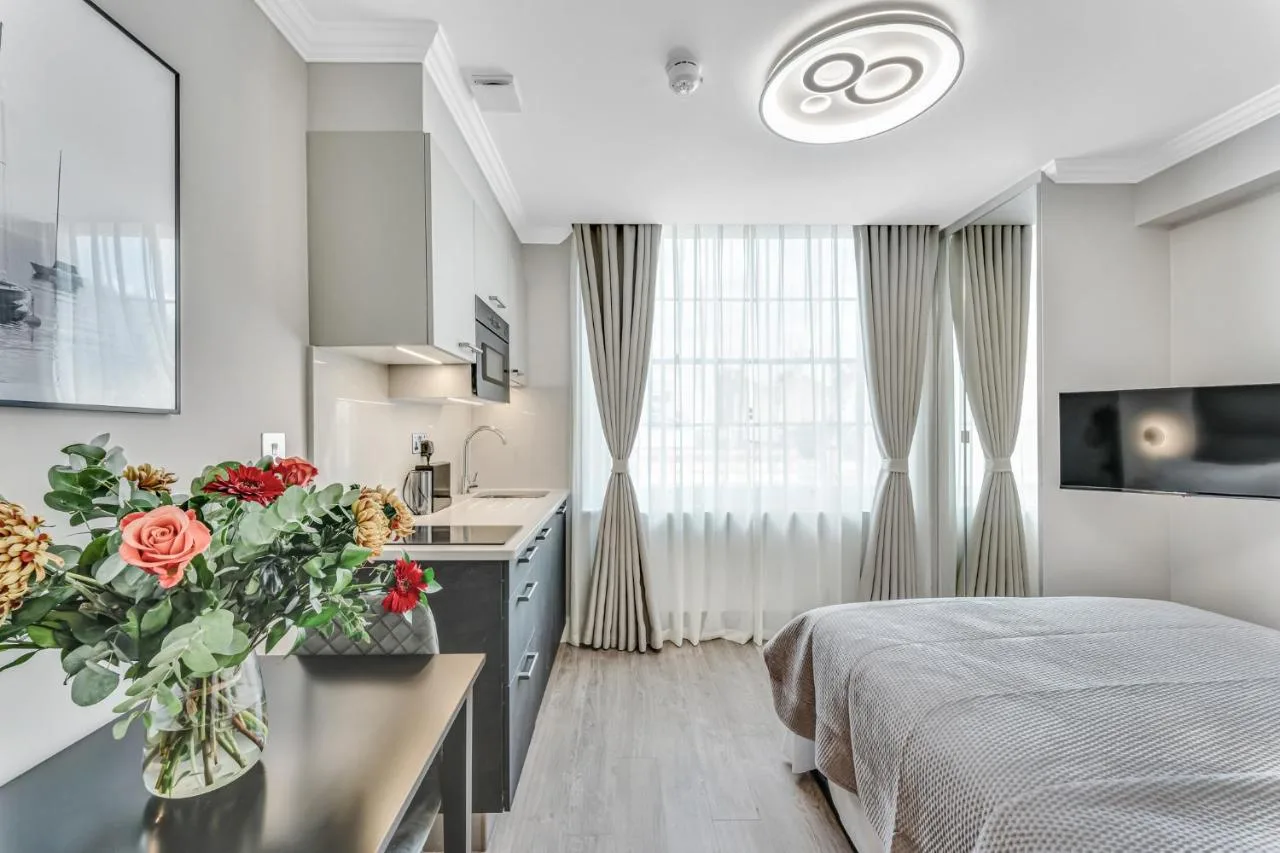 Bright bedroom with bed and vase of flowers at Cleveland Residences